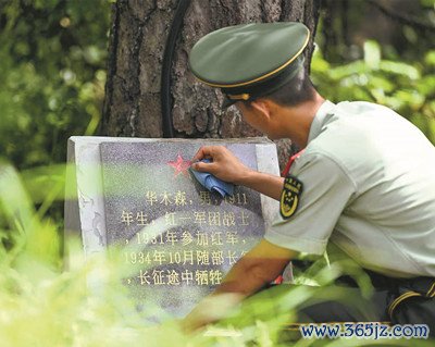 该支队一名战士擦拭位于“红军村”后山的烈士墓碑。